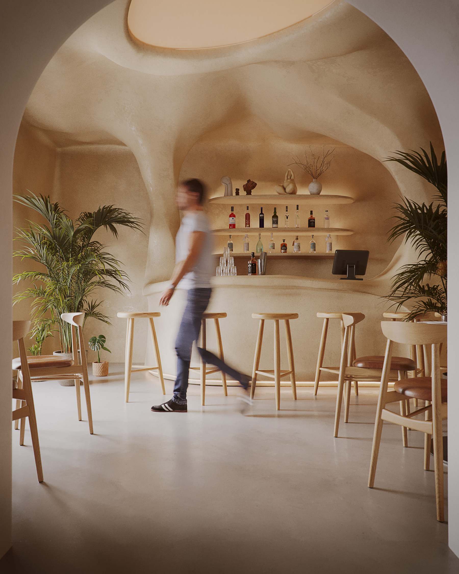 Rendering of the NEXUS bar, a curved cave-like arch over a wood bar with stools and plants