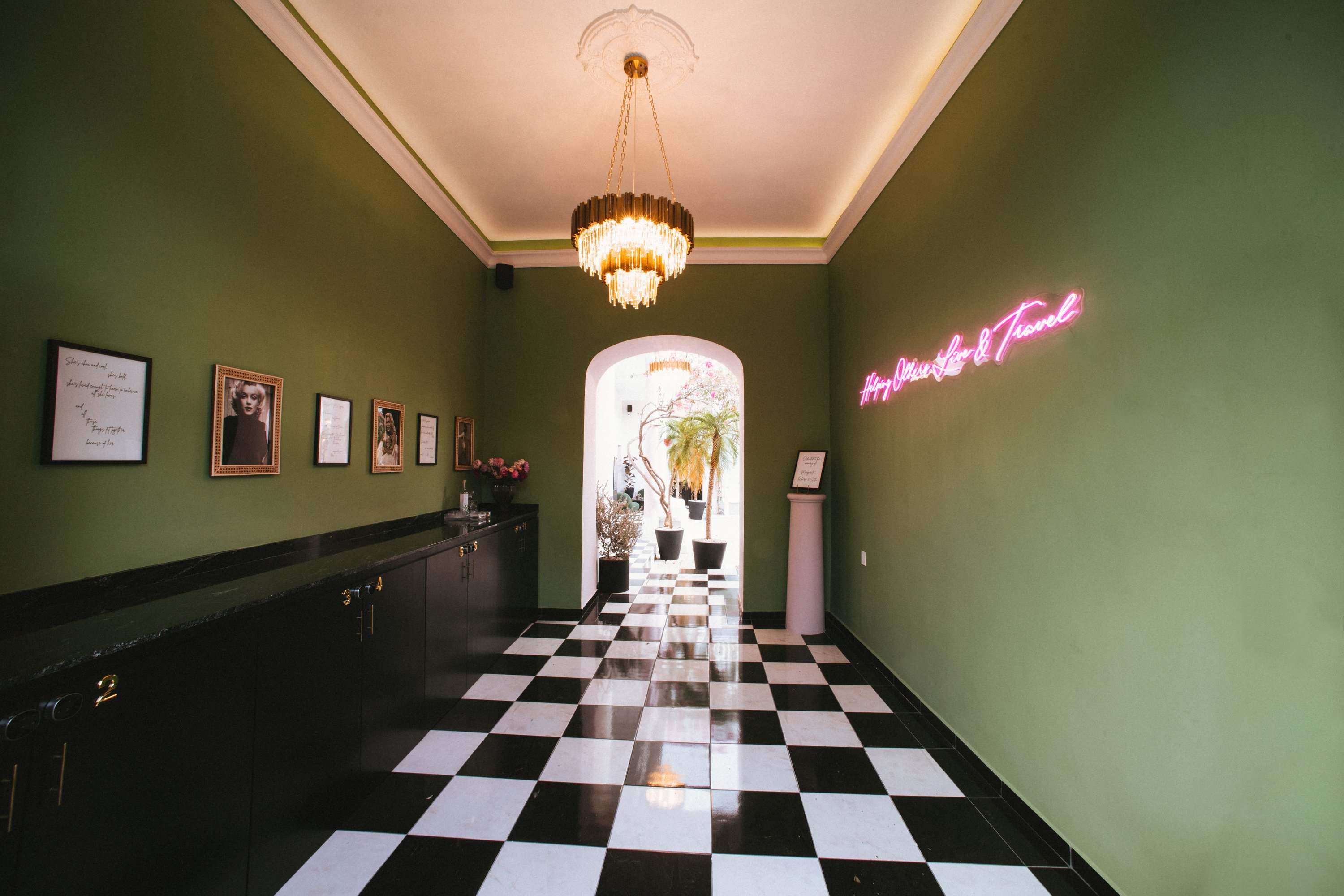 Lobby of a HOLT hotel, a long green hall with a checkerboard floor, a chandelier and a pink neon sign